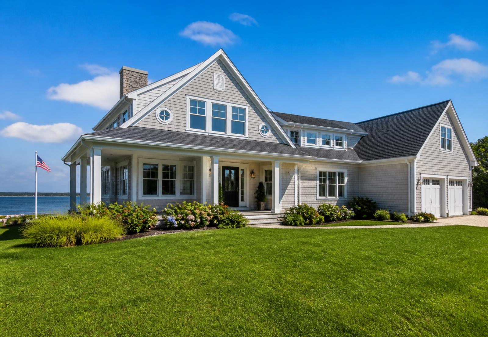 Coastal home with newly installed light gray vinyl siding and white trim